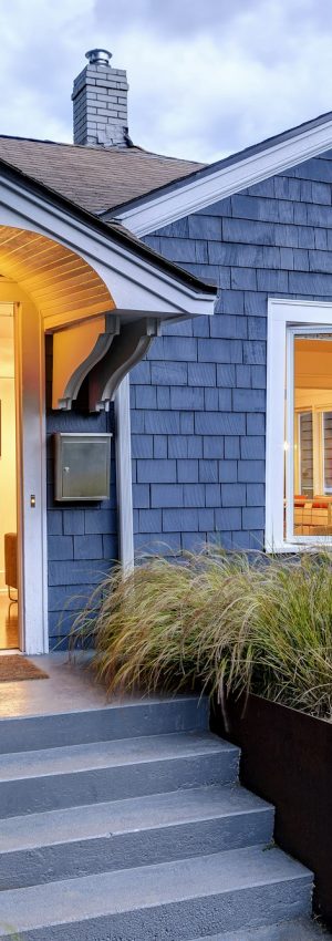 Illuminated front stoop and of blue house